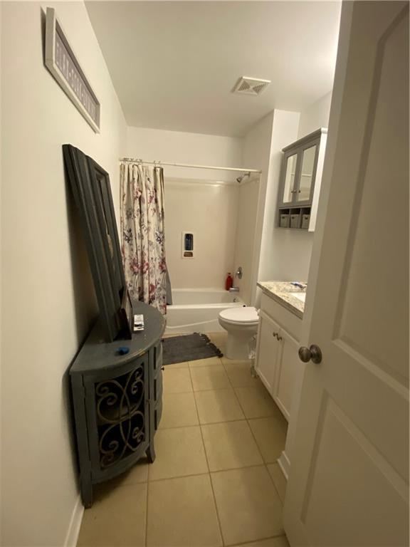 full bathroom with toilet, tile patterned floors, visible vents, shower / bathtub combination with curtain, and vanity