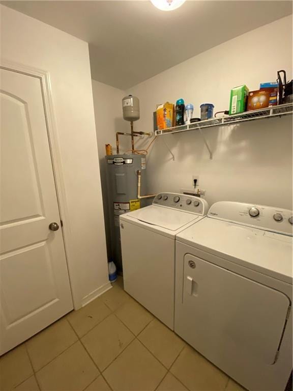 laundry area with laundry area, light tile patterned floors, independent washer and dryer, and water heater