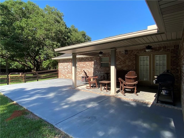 view of patio featuring area for grilling, fence, and ceiling fan