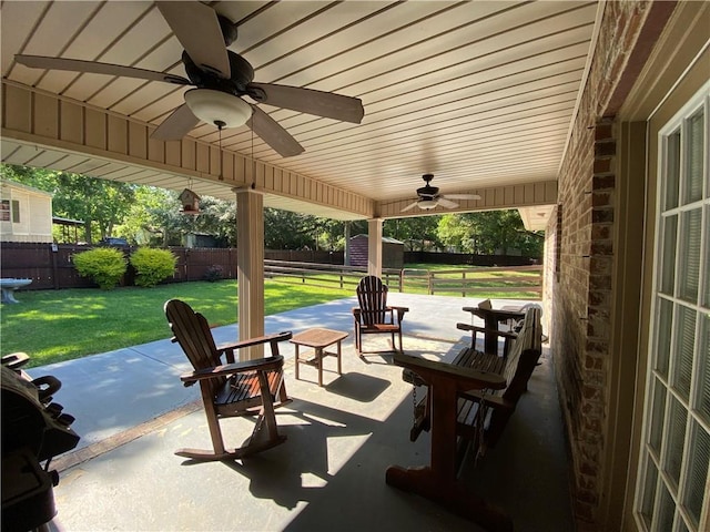 view of patio / terrace with a ceiling fan, an outdoor structure, and a fenced backyard