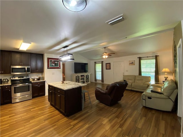 kitchen with stainless steel appliances, open floor plan, and wood finished floors