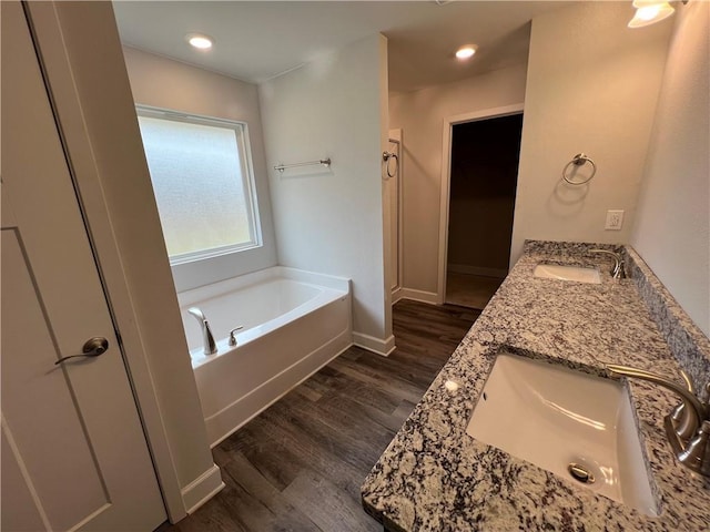 bathroom featuring wood-type flooring, a tub, and vanity