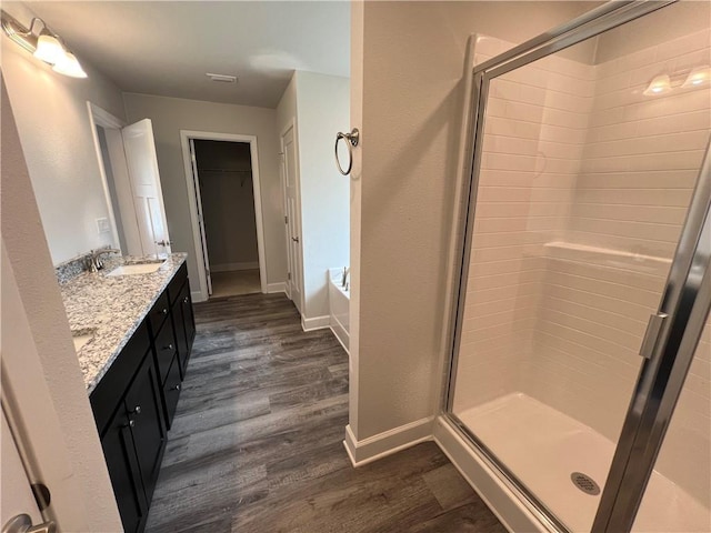 bathroom with hardwood / wood-style flooring, vanity, and walk in shower