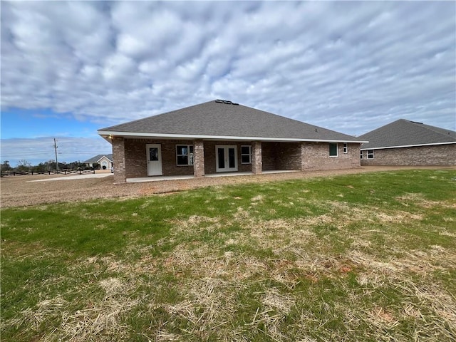 back of property featuring a lawn