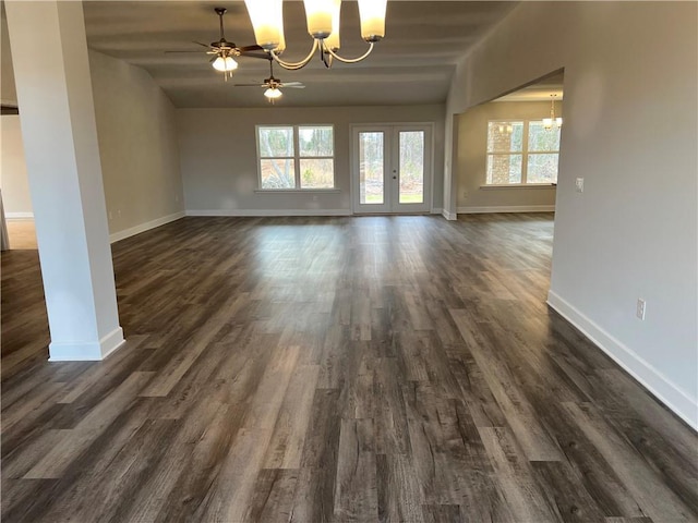 unfurnished dining area with dark wood-type flooring and ceiling fan with notable chandelier