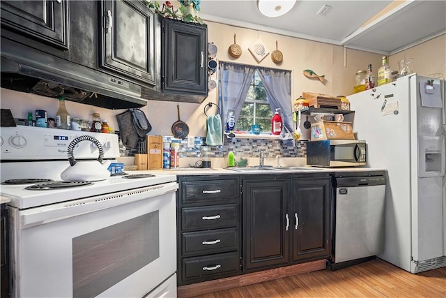 kitchen featuring light hardwood / wood-style floors, decorative backsplash, stainless steel appliances, and sink