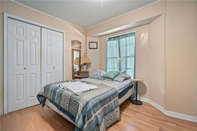 bedroom featuring a closet, a textured ceiling, and light hardwood / wood-style floors