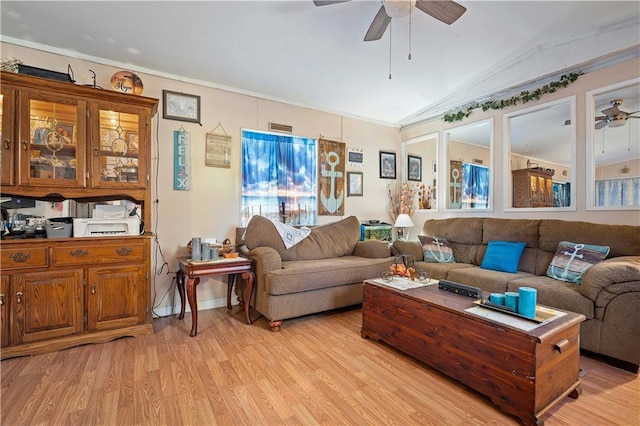 living room with ornamental molding, ceiling fan, light wood-type flooring, and vaulted ceiling