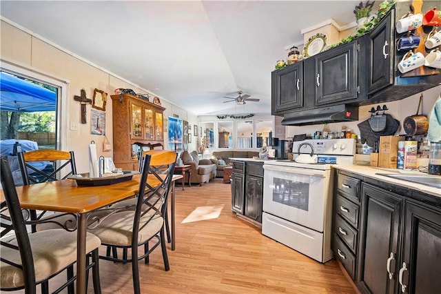 kitchen with vaulted ceiling, electric range, light hardwood / wood-style floors, and ceiling fan