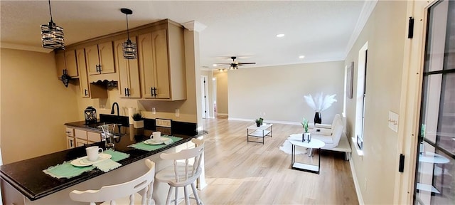 kitchen with light hardwood / wood-style flooring, hanging light fixtures, ornamental molding, sink, and ceiling fan