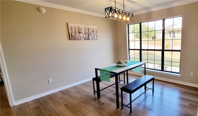 dining area featuring wood-type flooring, a wealth of natural light, and ornamental molding