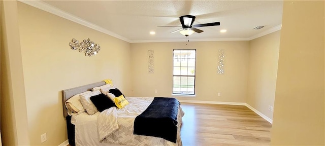 bedroom featuring ceiling fan, crown molding, and light wood-type flooring