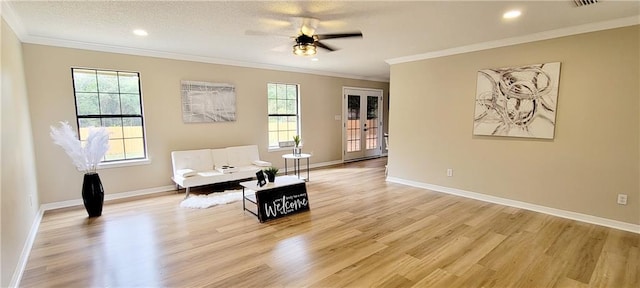 sitting room featuring light hardwood / wood-style floors, crown molding, a healthy amount of sunlight, and ceiling fan