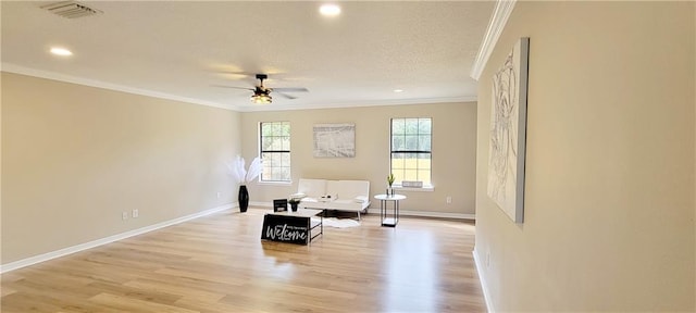 living area with crown molding, a textured ceiling, light wood-type flooring, and ceiling fan