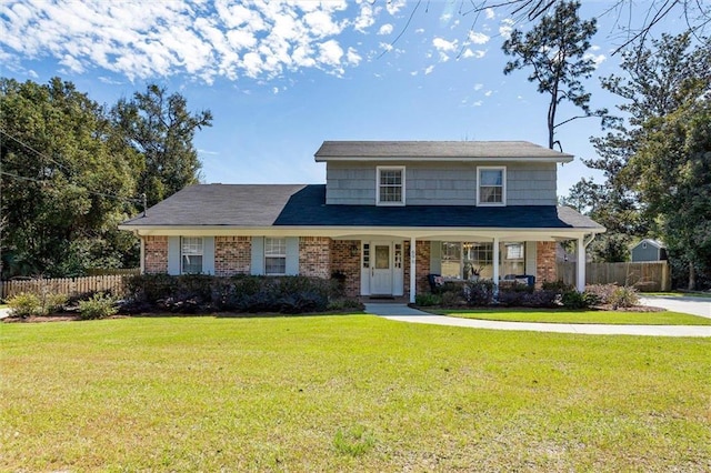 view of front of property with fence, a front lawn, and brick siding