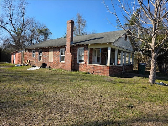 exterior space with brick siding, a chimney, and a front lawn