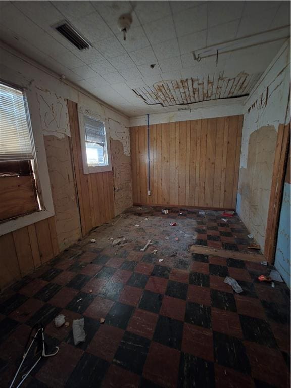 empty room with wood walls and visible vents