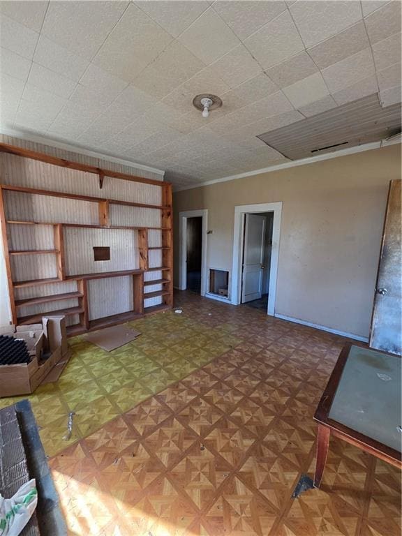 unfurnished living room featuring baseboards and crown molding