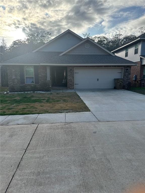 single story home featuring a garage, concrete driveway, and a front lawn