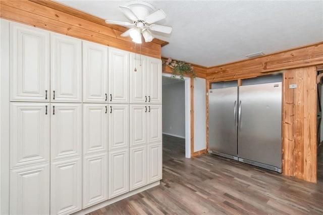 kitchen featuring white cabinets, ceiling fan, hardwood / wood-style floors, and stainless steel refrigerator