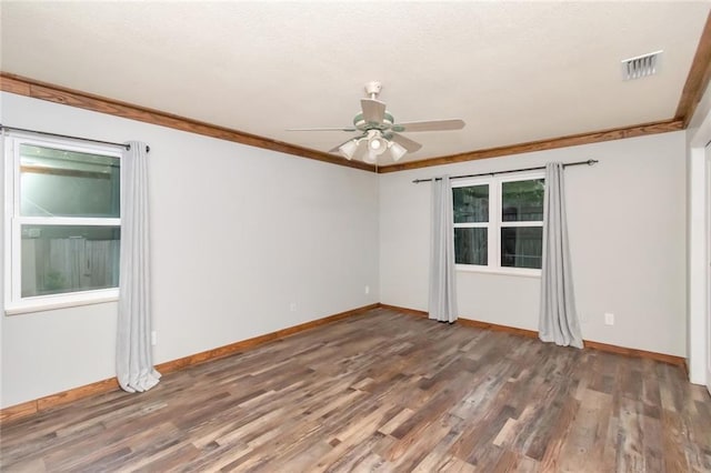 spare room with a wealth of natural light, ceiling fan, and dark hardwood / wood-style flooring