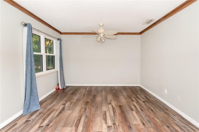 spare room featuring ceiling fan, hardwood / wood-style flooring, and crown molding