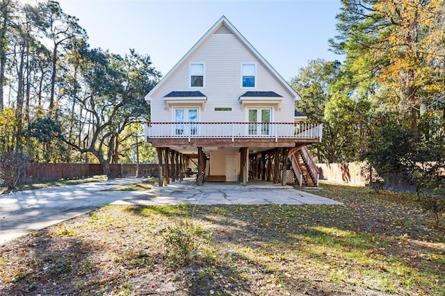 back of property featuring french doors, a deck, and a carport