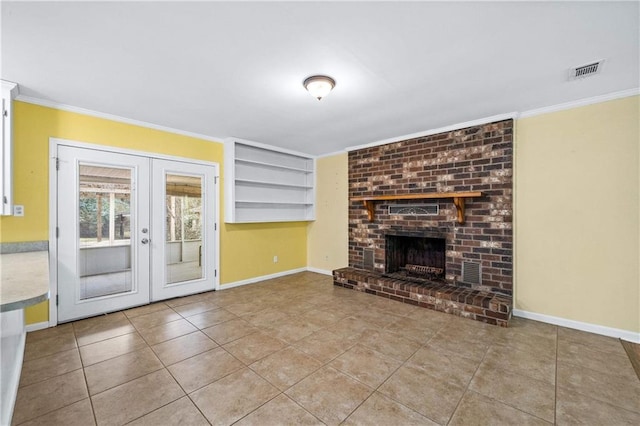 unfurnished living room featuring crown molding, light tile patterned flooring, a fireplace, and french doors