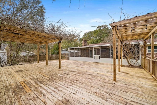 wooden deck with a sunroom and a pergola