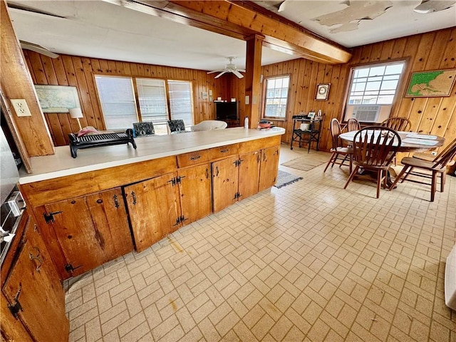 kitchen featuring light countertops, brown cabinetry, brick patterned floor, and ceiling fan