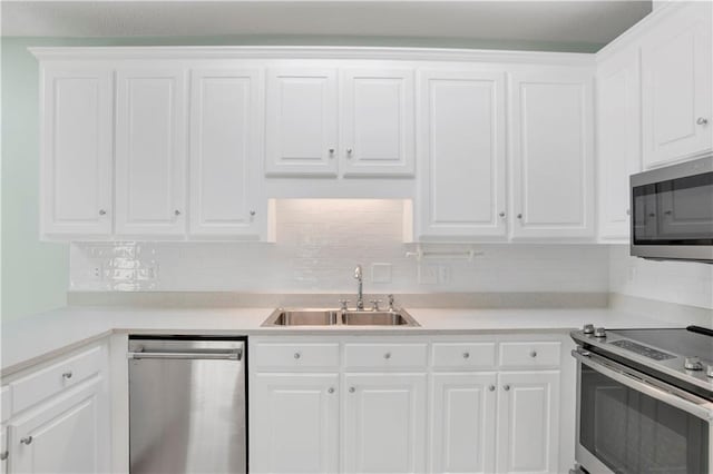 kitchen with sink, white cabinets, stainless steel appliances, and tasteful backsplash