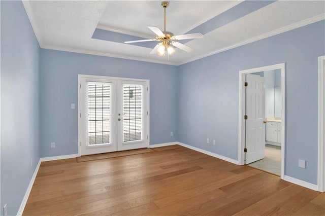 spare room featuring french doors, crown molding, wood-type flooring, and ceiling fan