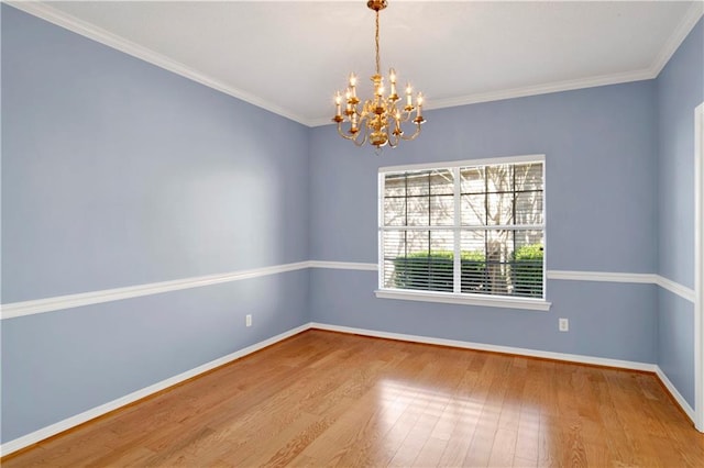 empty room featuring a notable chandelier, hardwood / wood-style flooring, and ornamental molding