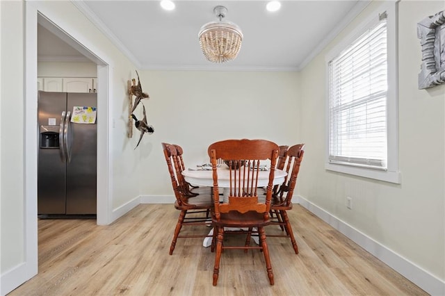 dining room with crown molding, a notable chandelier, and light hardwood / wood-style flooring