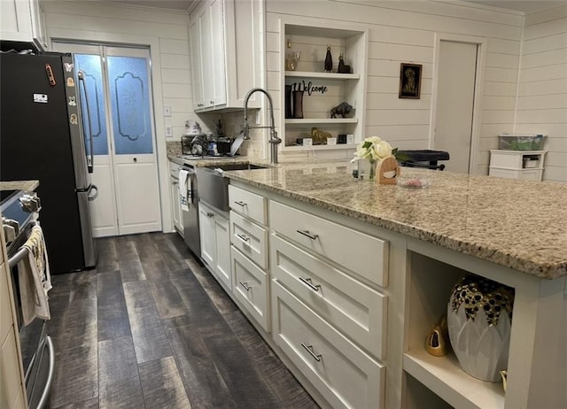 2911 Thornhill Dr, Mobile, AL 36606 - kitchen featuring stainless steel appliances, white cabinets, dark wood-style flooring, light stone countertops, and wood walls