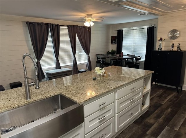 2911 Thornhill Dr, Mobile, AL 36606 - kitchen with wood walls, ceiling fan, white cabinets, dark wood-style floors, and light stone counters
