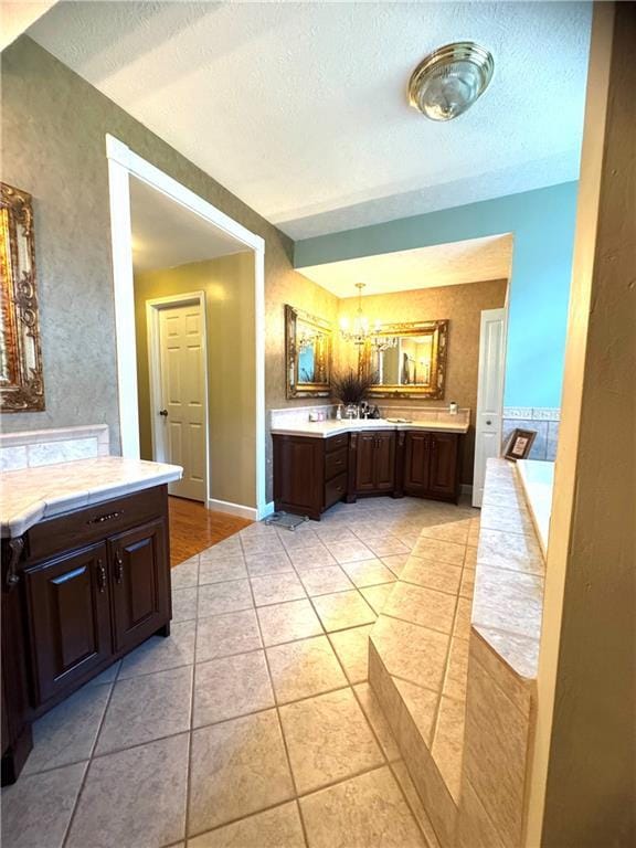 14522 St Stephens Ave, Chatom, AL 36518 - bathroom featuring tile patterned floors, a textured ceiling, a bath, vanity, and a chandelier