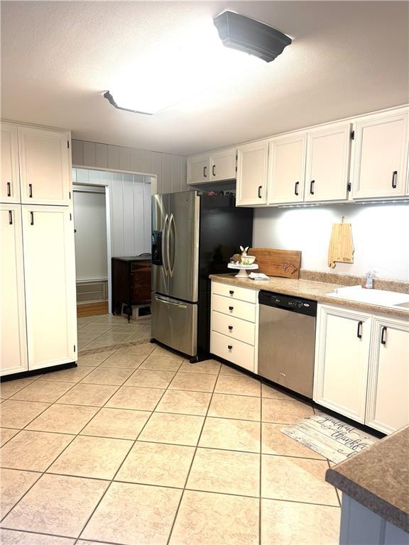 14522 St Stephens Ave, Chatom, AL 36518 - kitchen with light tile patterned floors, white cabinets, and appliances with stainless steel finishes