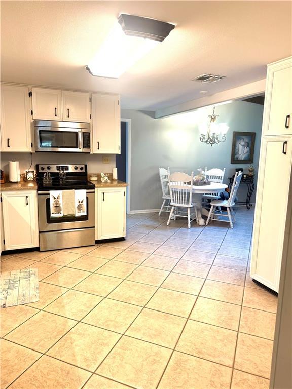 14522 St Stephens Ave, Chatom, AL 36518 - kitchen with white cabinetry, appliances with stainless steel finishes, visible vents, and light tile patterned floors