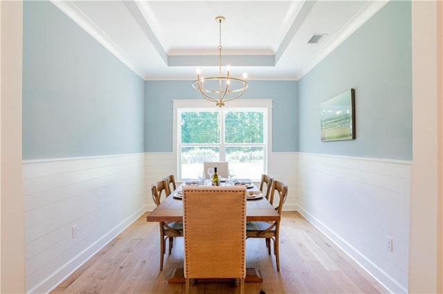 305 Hannah Chase Way, Satsuma, AL 36572 - dining space featuring a wainscoted wall, a chandelier, light wood-style flooring, a tray ceiling, and crown molding