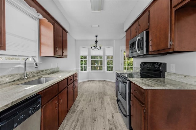 13163 Buckthorn Ct, Mobile, AL 36608 - kitchen with appliances with stainless steel finishes, light wood finished floors, a chandelier, hanging light fixtures, and light stone countertops