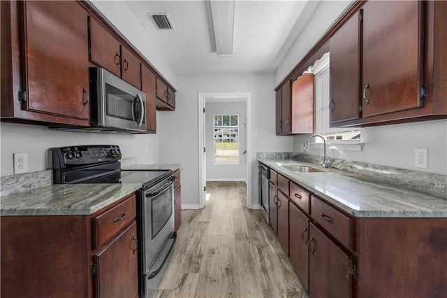13163 Buckthorn Ct, Mobile, AL 36608 - kitchen with range with electric stovetop, stainless steel microwave, light wood-type flooring, and a textured ceiling