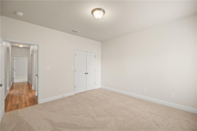 unfurnished bedroom featuring a closet and dark colored carpet