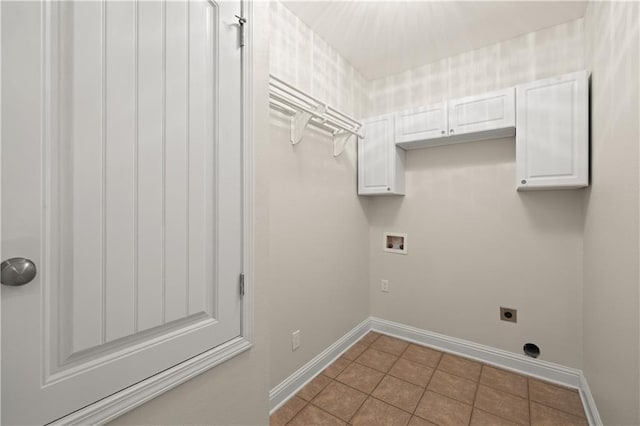 clothes washing area featuring cabinets, light tile flooring, and hookup for an electric dryer