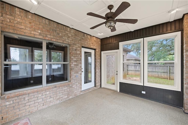 unfurnished sunroom featuring ceiling fan