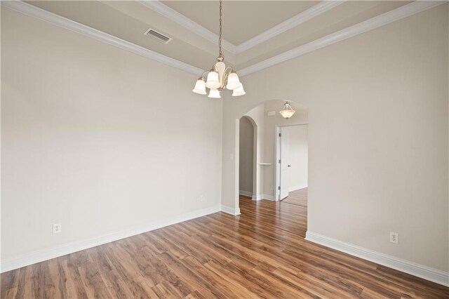 unfurnished room featuring ornamental molding, dark hardwood / wood-style floors, a chandelier, and a raised ceiling