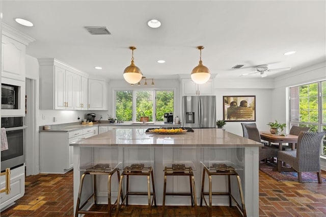 65 Byrnes Blvd, Mobile, AL 36608 - kitchen featuring stainless steel appliances, a sink, a breakfast bar, white cabinetry, and a kitchen island
