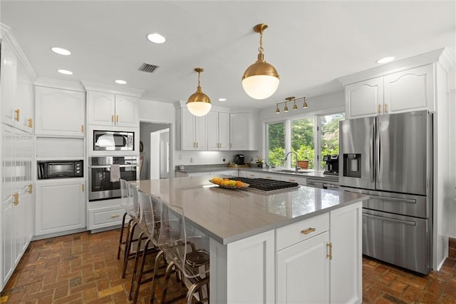 65 Byrnes Blvd, Mobile, AL 36608 - kitchen featuring stainless steel appliances, brick flooring, a sink, white cabinets, and recessed lighting