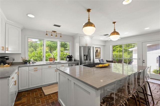 65 Byrnes Blvd, Mobile, AL 36608 - kitchen with stainless steel fridge with ice dispenser, a sink, brick floors, healthy amount of natural light, and recessed lighting
