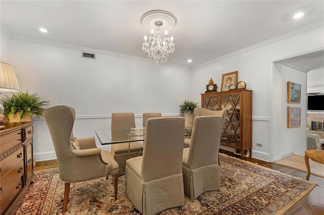 65 Byrnes Blvd, Mobile, AL 36608 - dining area featuring a chandelier, crown molding, wood finished floors, a brick fireplace, and recessed lighting